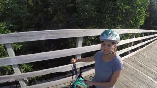 Bisiklet üzerinde köprü yürüyen bir kadın — Stok video