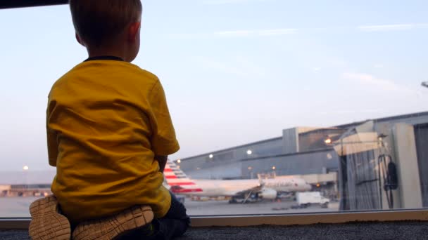 Μικρό αγόρι ψάχνει μέσα από το παράθυρο στο αεροδρόμιο — Αρχείο Βίντεο