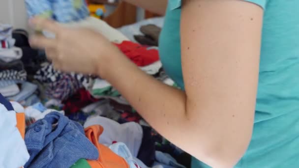 Μητέρα διαλογής μέσα από τα παιδικά ρούχα — Αρχείο Βίντεο
