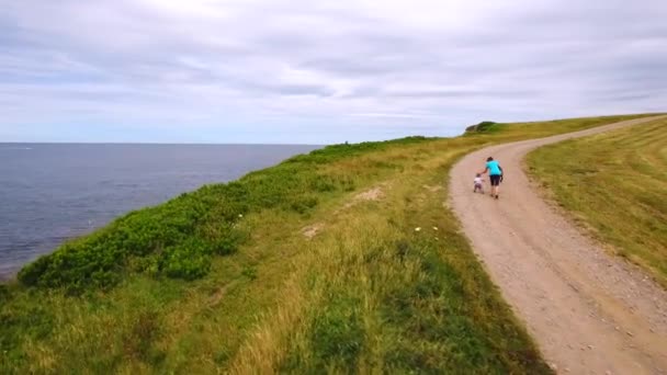 Moeder en baby wandelen langs de kust van de Oceaan — Stockvideo