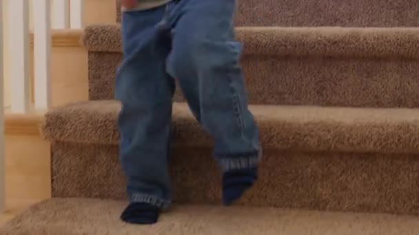 Boy walks down the stairs in his house — Stock Video