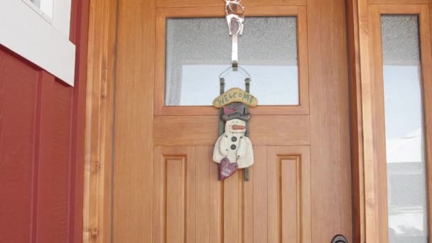 Un cartel de bienvenida cuelga en la puerta de una casa — Vídeo de stock