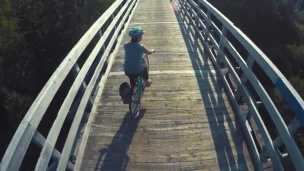 Een vrouw fietsen over brug — Stockvideo