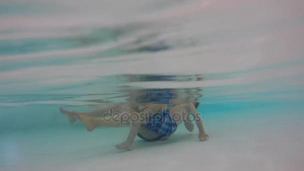 Um tiro subaquático de um menino com a mãe na piscina — Vídeo de Stock