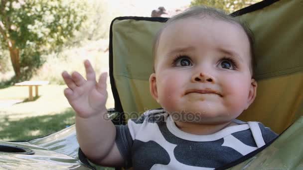 Baby eten buiten in een park op picknick — Stockvideo