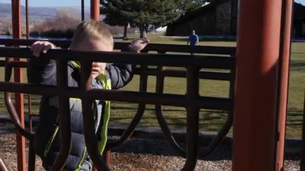 Menino joga no playground com slides e brinquedos — Vídeo de Stock