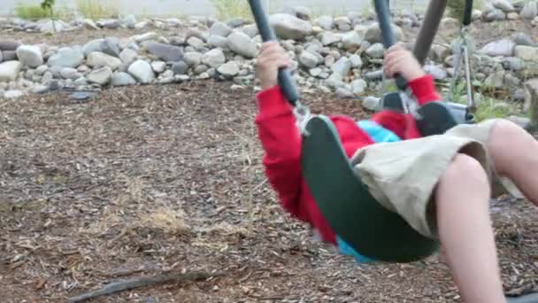Menino balançando em um playground em sua casa — Vídeo de Stock