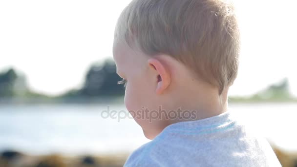 Junge wirft Stein ins Meer — Stockvideo