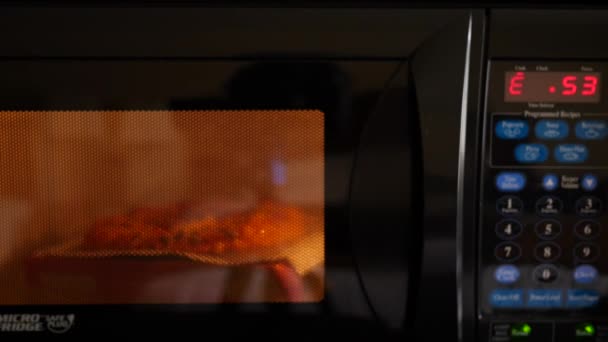 A microwave pizza cooking in a hotel room — Stock Video