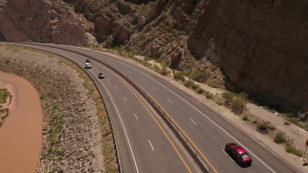 Auto che guidano in un canyon desertico lungo il fiume — Video Stock