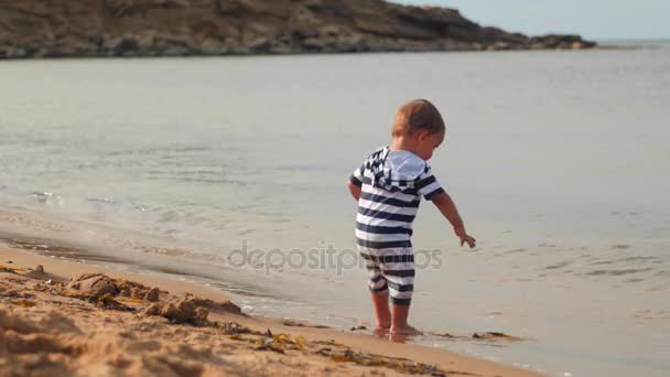 Niño juega en la playa de arena — Vídeos de Stock