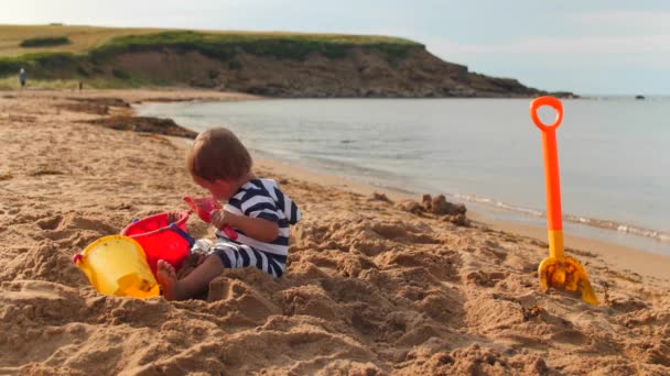 Batole chlapec hraje na písečné pláži — Stock video