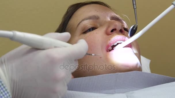 Dentista trabajando en una mujer dientes en una silla — Vídeo de stock