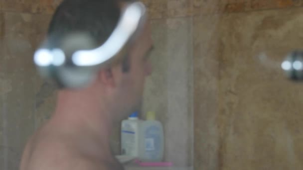 Dolly shot of a man in a shower — Stockvideo