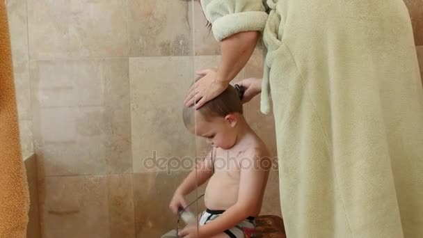 Mutter schneidet Jungen Haare in der Dusche — Stockvideo