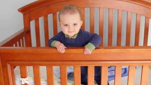 Förtjusande baby pojke i hans spjälsäng — Stockvideo