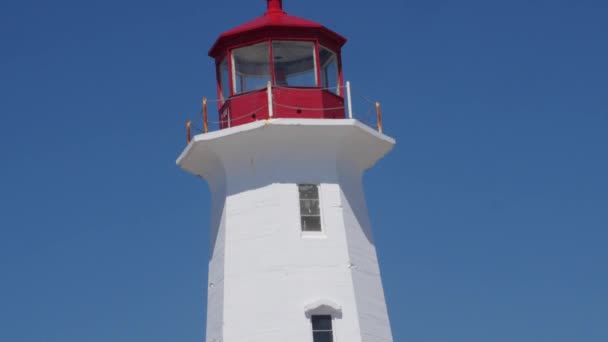 Touristen spazieren um den schönen Leuchtturm in Peggys Bucht — Stockvideo