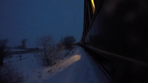 Поезд, идущий через снежные поля в шторм — стоковое видео