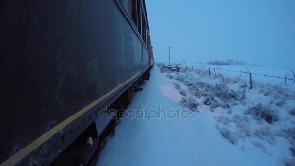 Поезд, идущий через заснеженные поля — стоковое видео
