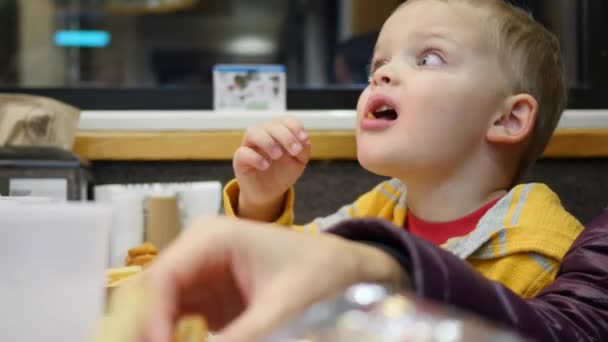 Família comer hambúrgueres com batatas fritas — Vídeo de Stock