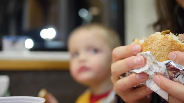Família comer hambúrgueres com batatas fritas — Vídeo de Stock
