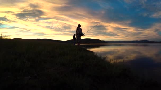 Una persona che pesca su un bellissimo lago di montagna — Video Stock