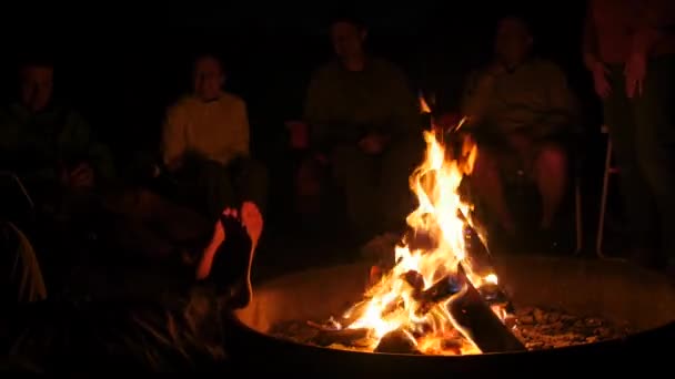Uma família sentada à volta de uma fogueira à noite — Vídeo de Stock