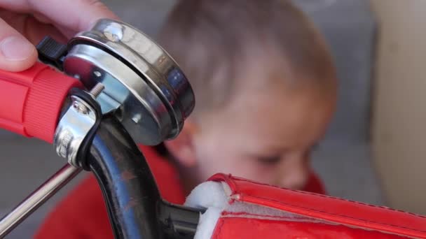 Padre instala una campana en su bicicleta de niño — Vídeos de Stock
