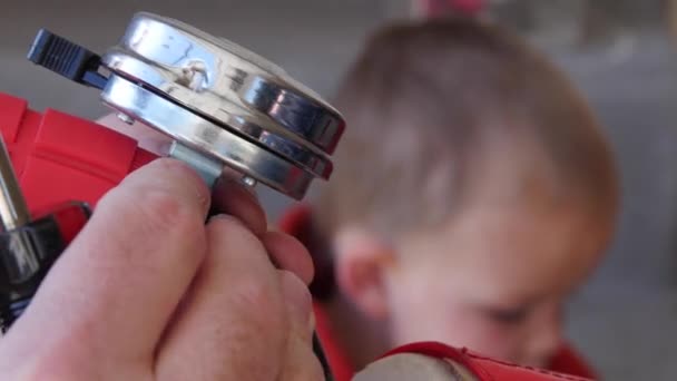 Père installe une cloche sur son vélo garçon — Video