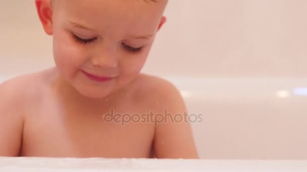 Niño jugando con un juguete en su bañera — Vídeo de stock