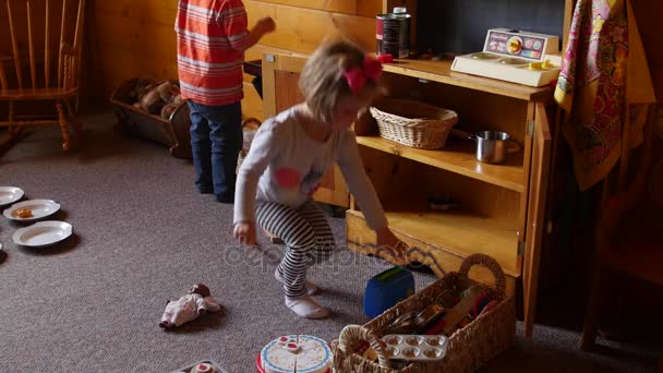 Девочка и мальчик играют вместе со своими игрушками — стоковое видео