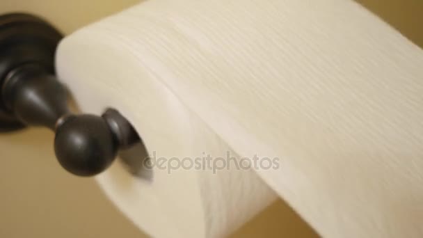 Рука хватает туалетную бумагу в ванной комнате — стоковое видео