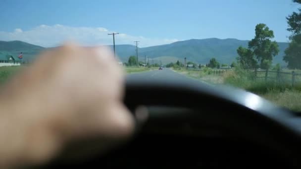 Чоловік водить машину на гірській дорозі — стокове відео