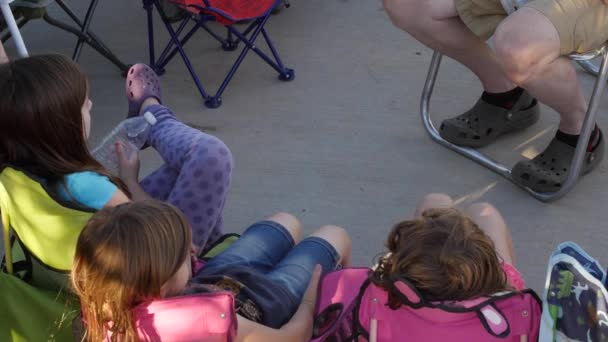 Los niños se sientan en sillas de campamento mientras acampan — Vídeo de stock