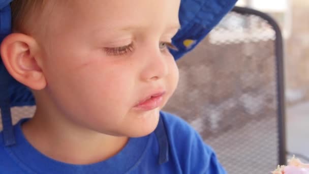 Chłopak cieszy się stożek zimne lody Truskawkowe — Wideo stockowe