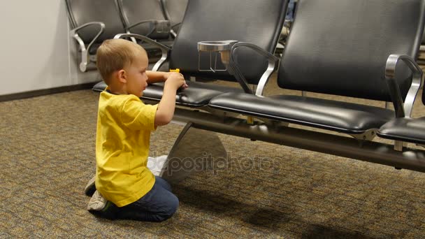 Liten pojke leker med leksak på flygplatsen — Stockvideo