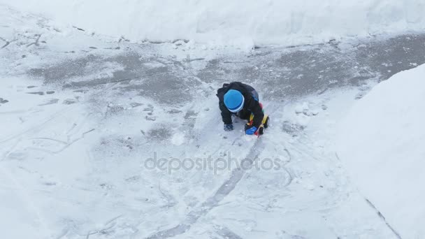 Niño jugando con juguete tractor en la nieve — Vídeo de stock