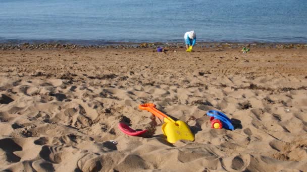 Jongen speelt in het zand op het strand van de Oceaan — Stockvideo