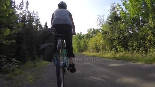 Mujer montando en una pista de ciclismo en el bosque — Vídeo de stock