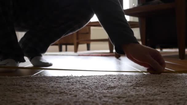 Людина вимірює підлогу за допомогою мірної стрічки — стокове відео