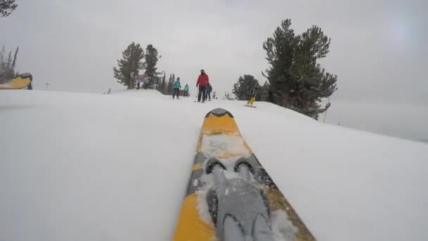 Pessoas descendo esqui em uma estância de esqui de montanha — Vídeo de Stock