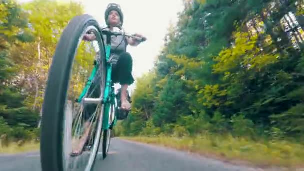 Mulher de bicicleta em uma floresta em trilha de bicicleta — Vídeo de Stock