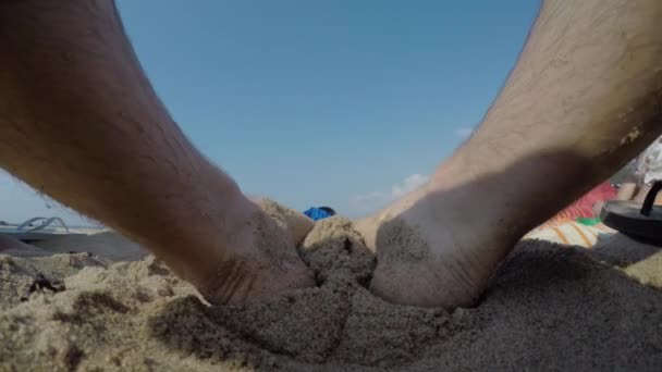 Mężczyzna siedzi na piaszczystej plaży nad oceanem — Wideo stockowe