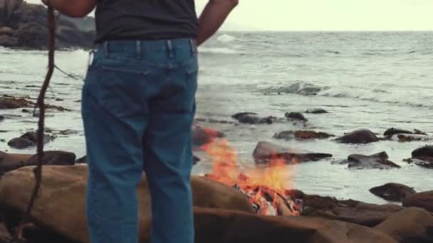 Man burns garbage on the ocean shore — Stock Video