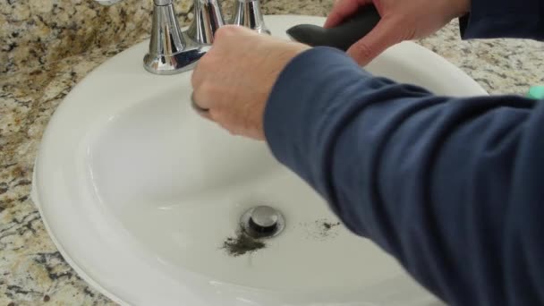 Člověk čistí vlasy z jímky po holení vousů — Stock video