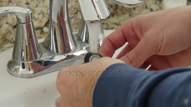 Man cleans hair from the sink after shaving his beard — Stock Video