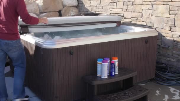 Man closes hot tub cover after putting in chemicals — Stock Video