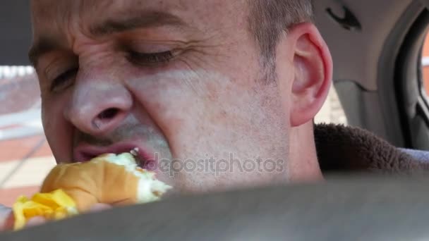 Man fastfood te eten in de auto — Stockvideo