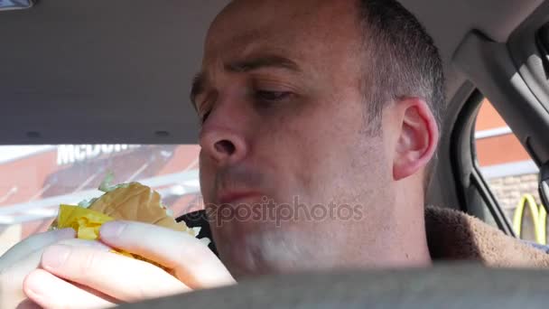 Hombre comiendo comida rápida en su coche — Vídeos de Stock