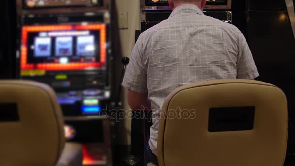 Человек играет на игровом автомате в казино — стоковое видео